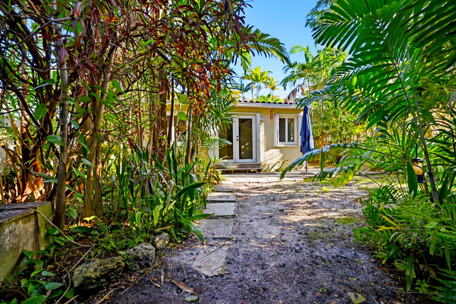 Garden path in the fenced backyard with layered tropical planting