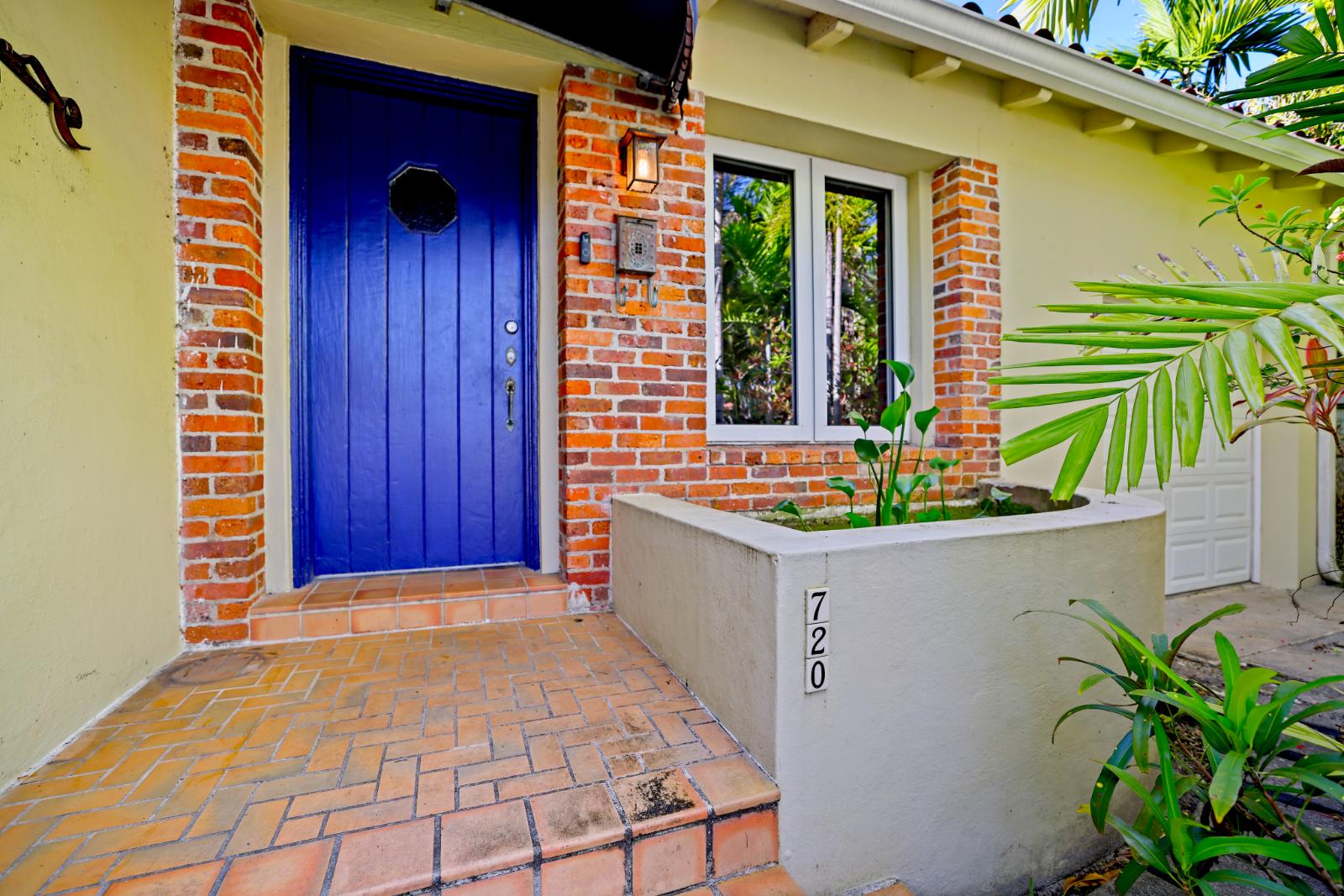 Front entry with blue door and Belle Meade tropical landscaping