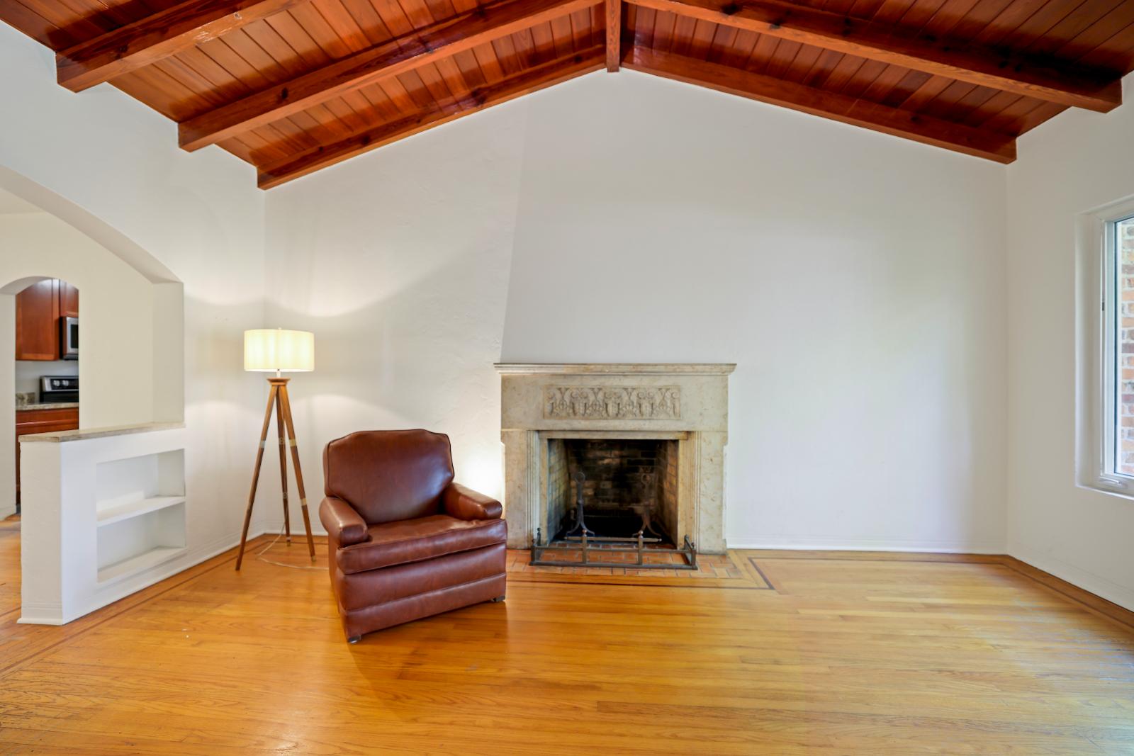 Living room with fireplace, hardwood floors, and strong architectural character
